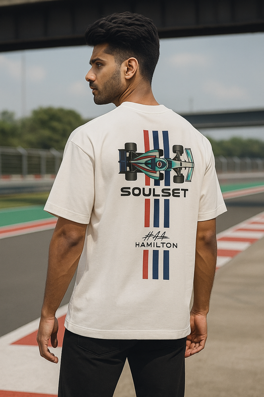 Men wearing oversized white F1-inspired SoulSet t-shirt with #44 graphic at a racetrack – stylish motorsport streetwear by SoulSet.Store
