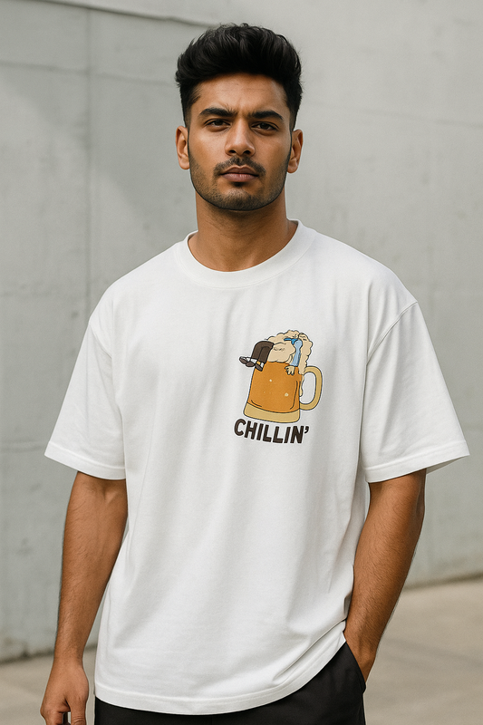 ndian  male model wearing SoulSet white oversized graphic tee featuring CHILLIN' beer mug design – trendy streetwear look for Gen Z and millennial fashion.