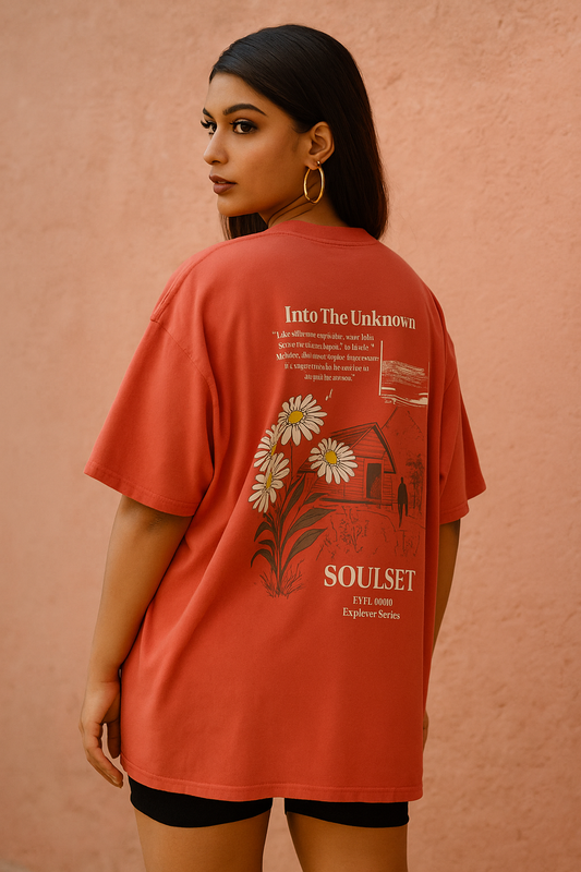 Person wearing a red t-shirt with floral design and text on a pink background