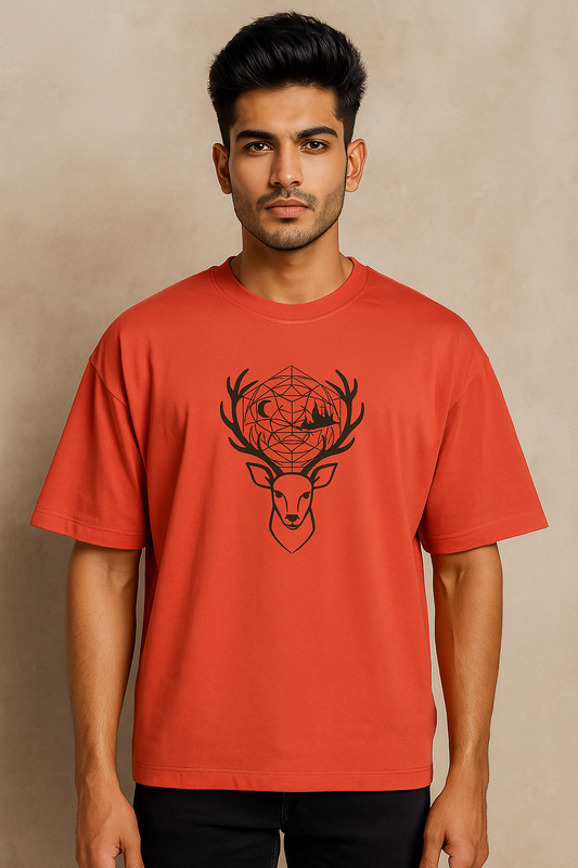 Oversized unisex t-shirt featuring a minimalist deer head with sacred geometry antlers, moon and mountain silhouettes, and a full-back design of a stag on a cliff with a glowing moon and forest tree hem – premium 240 GSM cotton, made in India.